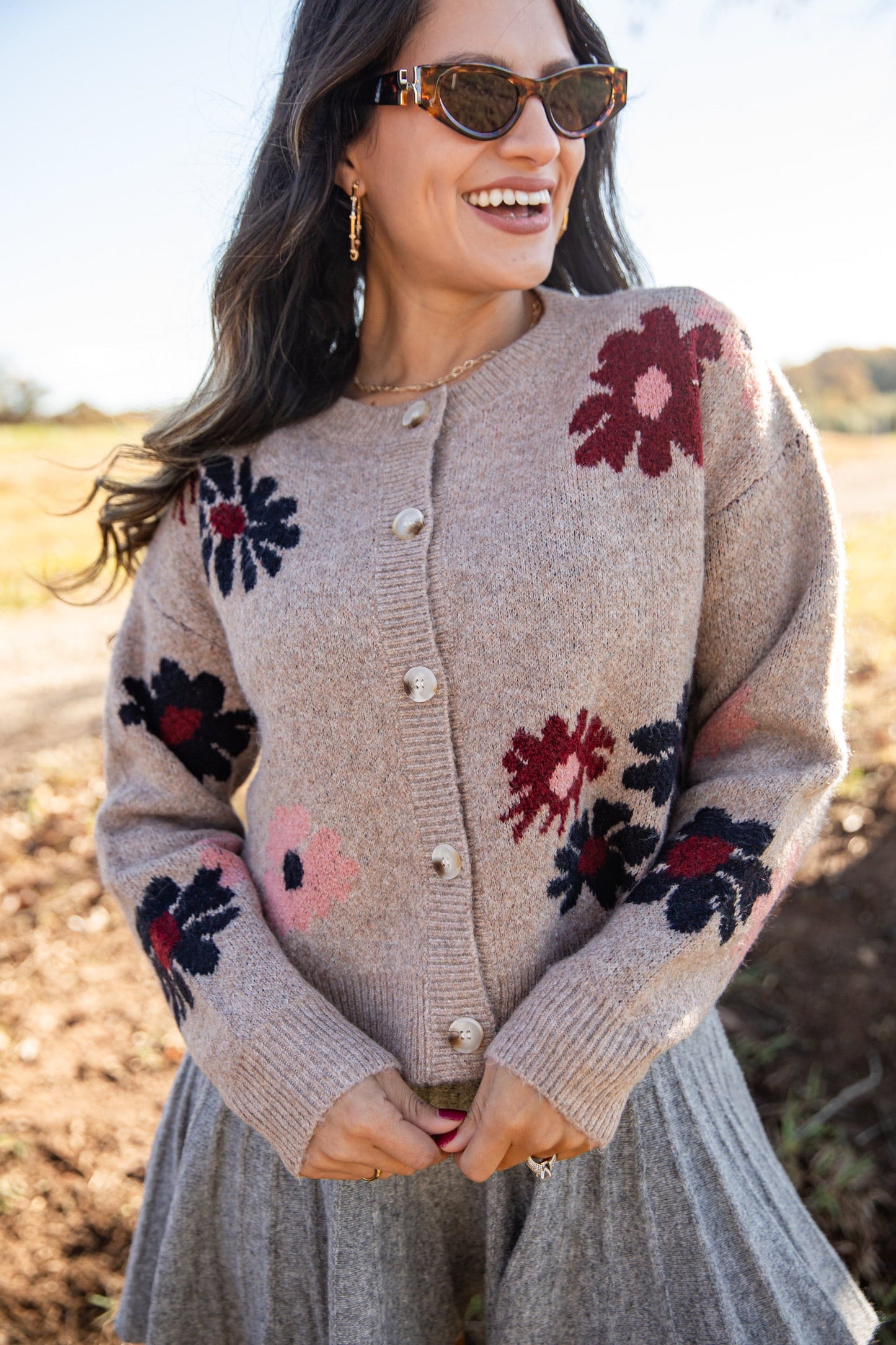 Woman wearing a floral-patterned cardigan in an outdoor setting