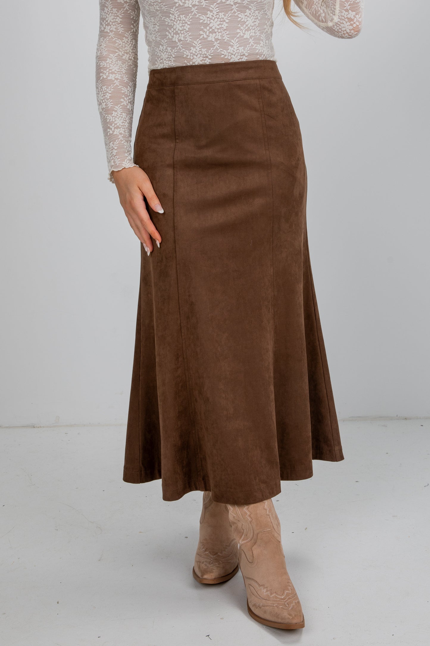 Brown suede skirt worn by a person on a white background