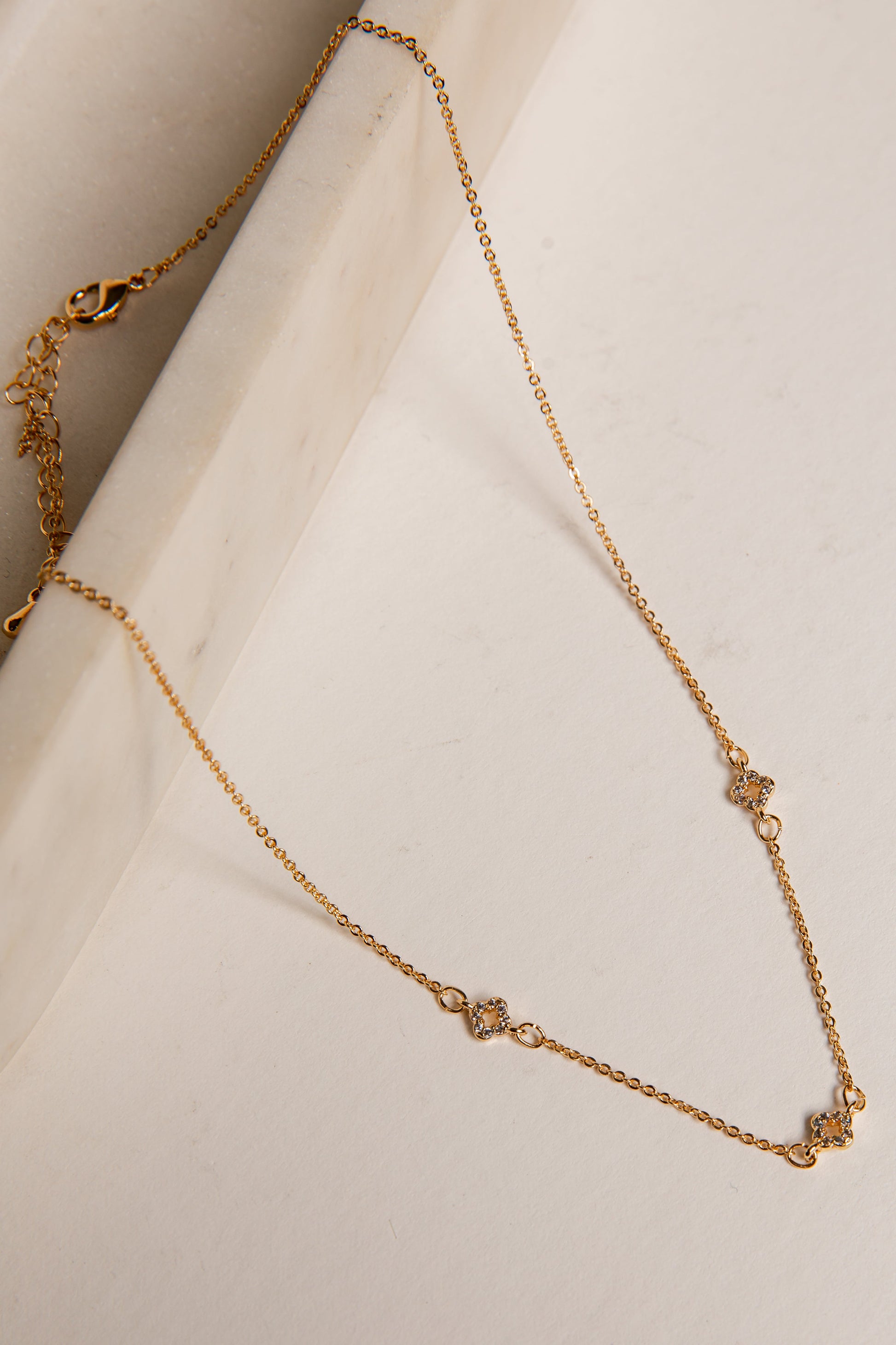 Gold necklace on a white surface
