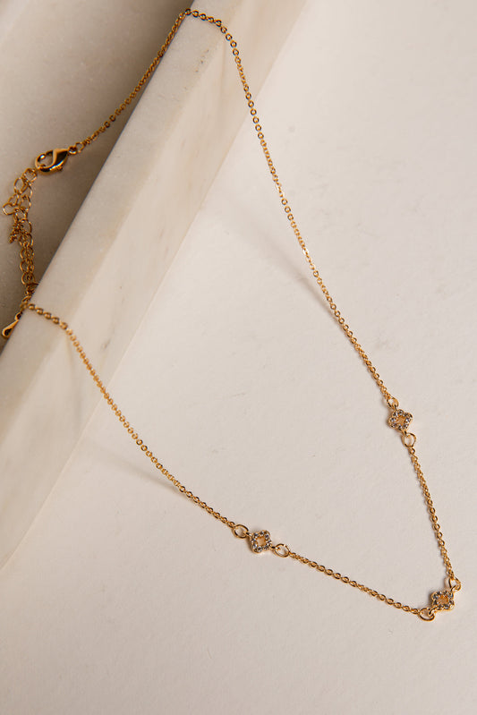 Gold necklace on a white surface