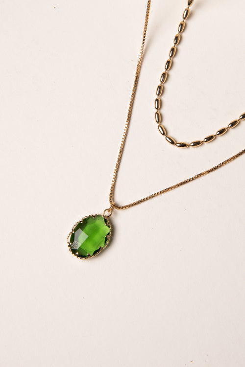 Necklace with a green pendant on a light background