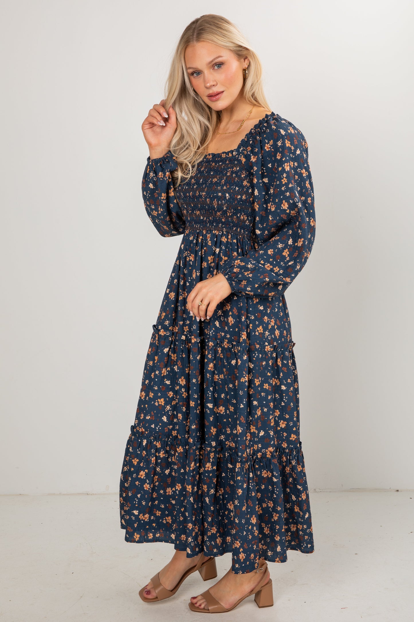 Woman wearing a navy floral dress against a white background