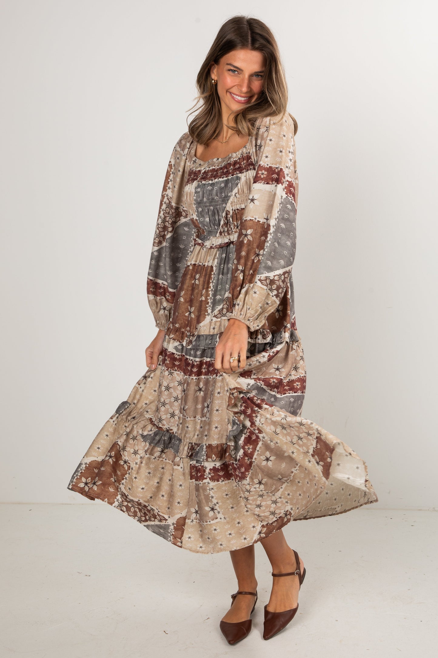 Woman wearing a patterned dress on a white background